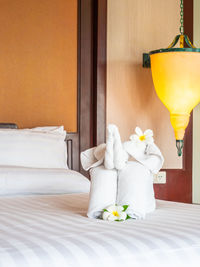 Flowers and towels on bed at hotel room