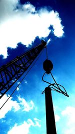 Low angle view of silhouette crane against sky