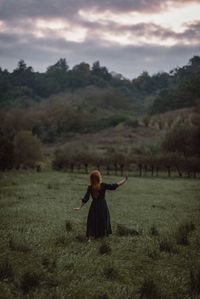 Rear view of woman standing on field