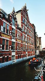 Canal amidst buildings against sky in city