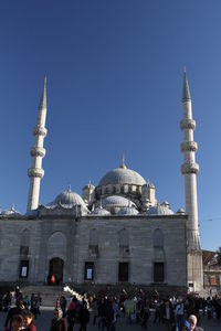 Group of people in front of cathedral against clear sky