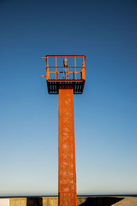 Low angle view of sign against clear blue sky