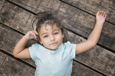 High angle view portrait of boy on hardwood floor