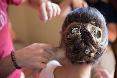 Cropped man hair styling bride during wedding 