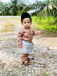 Portrait of cute boy in traditional clothing standing outdoors