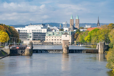 Bridge over river against buildings in city