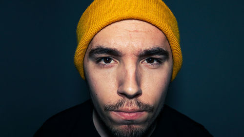 Close-up portrait of man wearing mask against black background