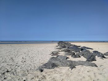 Scenic view of beach against clear blue sky