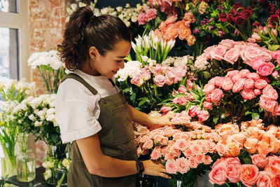 Florist analyzing flowers at shop
