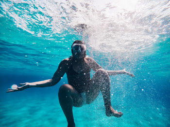 Full length of shirtless man swimming in pool