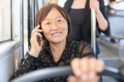 Portrait of smiling young woman using mobile phone