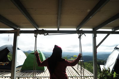 Rear view of woman standing by the window