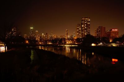 Illuminated cityscape against sky at night