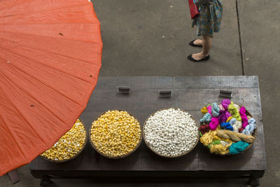 Low section of woman standing by silkworm cocoons on market stall