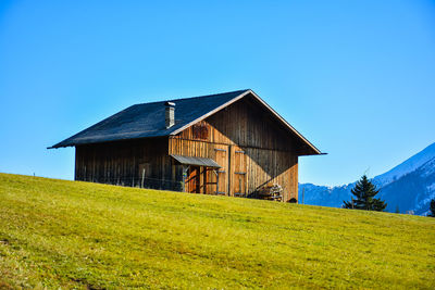 House on field against clear sky