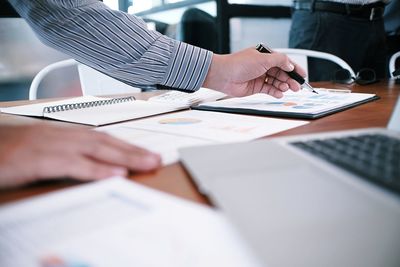 Cropped hands of businessman working on graph at desk in office