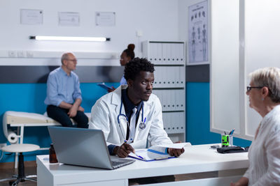 Doctor talking with senior woman at clinic