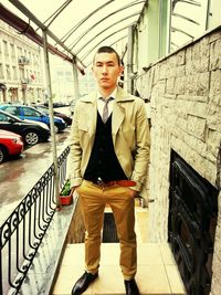 Portrait of young man standing on car