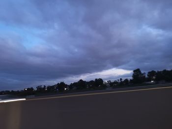 Road in city against sky at dusk