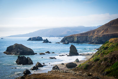 Scenic view of sea and mountains against sky