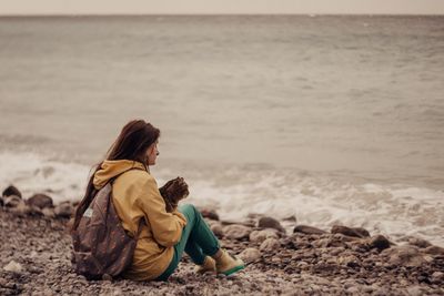 Rear view of women sitting on beach