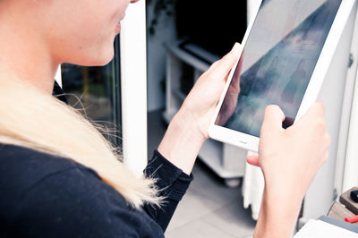 Midsection of smiling woman using digital tablet