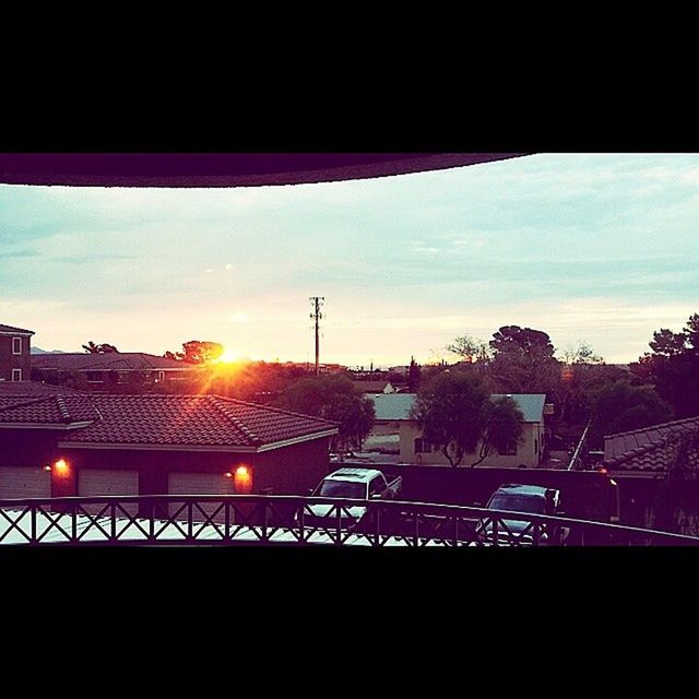 sunset, sun, built structure, sky, architecture, silhouette, railing, sunlight, transportation, building exterior, connection, sunbeam, tree, lens flare, power line, no people, electricity pylon, indoors, city