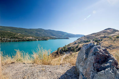 Panoramic view of lake and mountains against blue sky