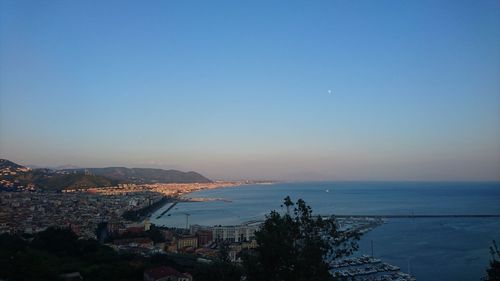 High angle view of townscape by sea against clear sky