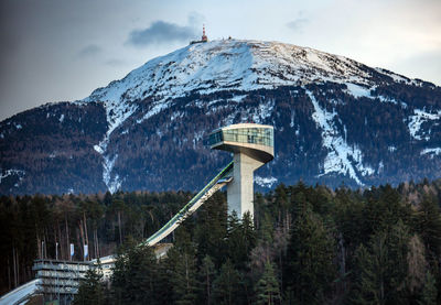 Built structure on snow covered mountains against sky