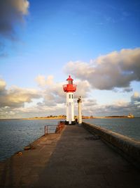 Lighthouse by sea against sky