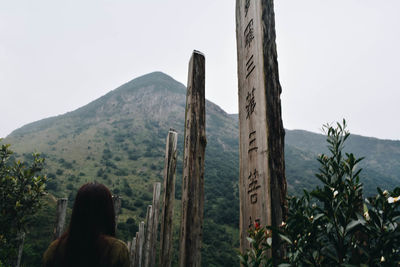 Rear view of man looking at mountain range against sky