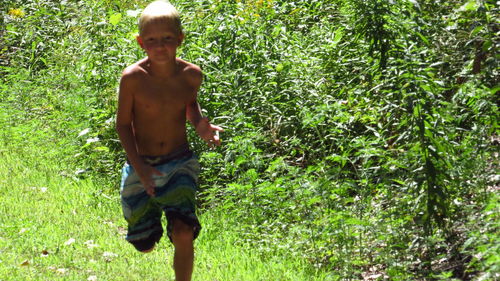 Portrait of shirtless boy standing on land