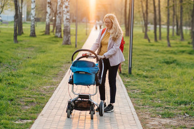 Mom walks with a stroller in the park