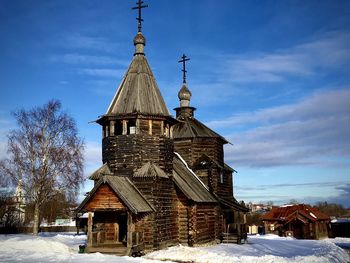 Building on field against sky during winter