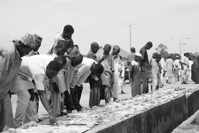 Group of people standing on land against clear sky