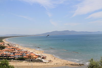 High angle view of town by sea against sky