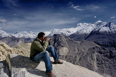 People on snowcapped mountain against sky