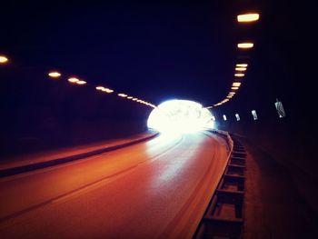 Illuminated tunnel at night