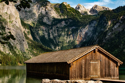 House by lake against mountains