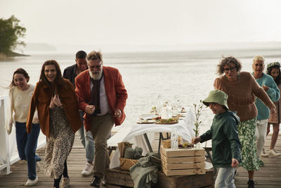 Family leaving dinner table by lake