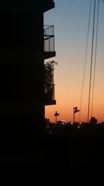 Silhouette buildings against clear sky during sunset