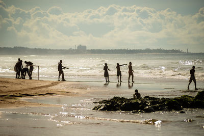 Fishermen pulling the fishing net from the sea with fish inside. boca do rio beach in salvador.