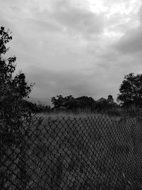 Fence on landscape against sky