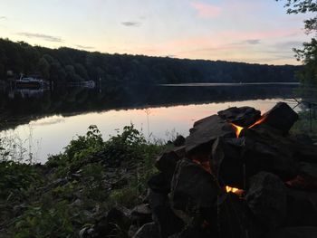 Reflection of trees in lake against sky during sunset