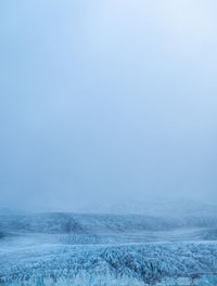 Scenic view of snow covered landscape against clear sky