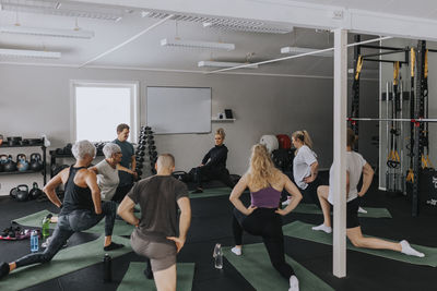 Men and woman stretching during fitness class