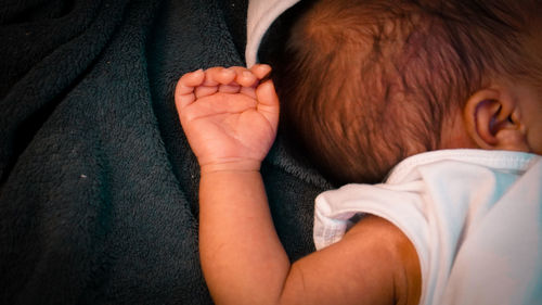 Midsection of father with baby on bed