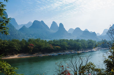 Scenic view of river and mountains against sky