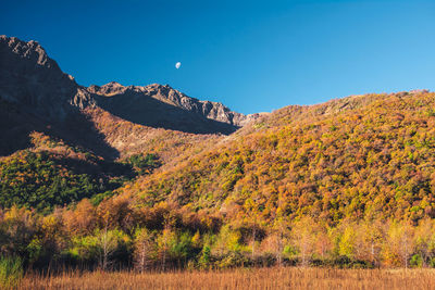 Scenic view of mountains against clear blue sky